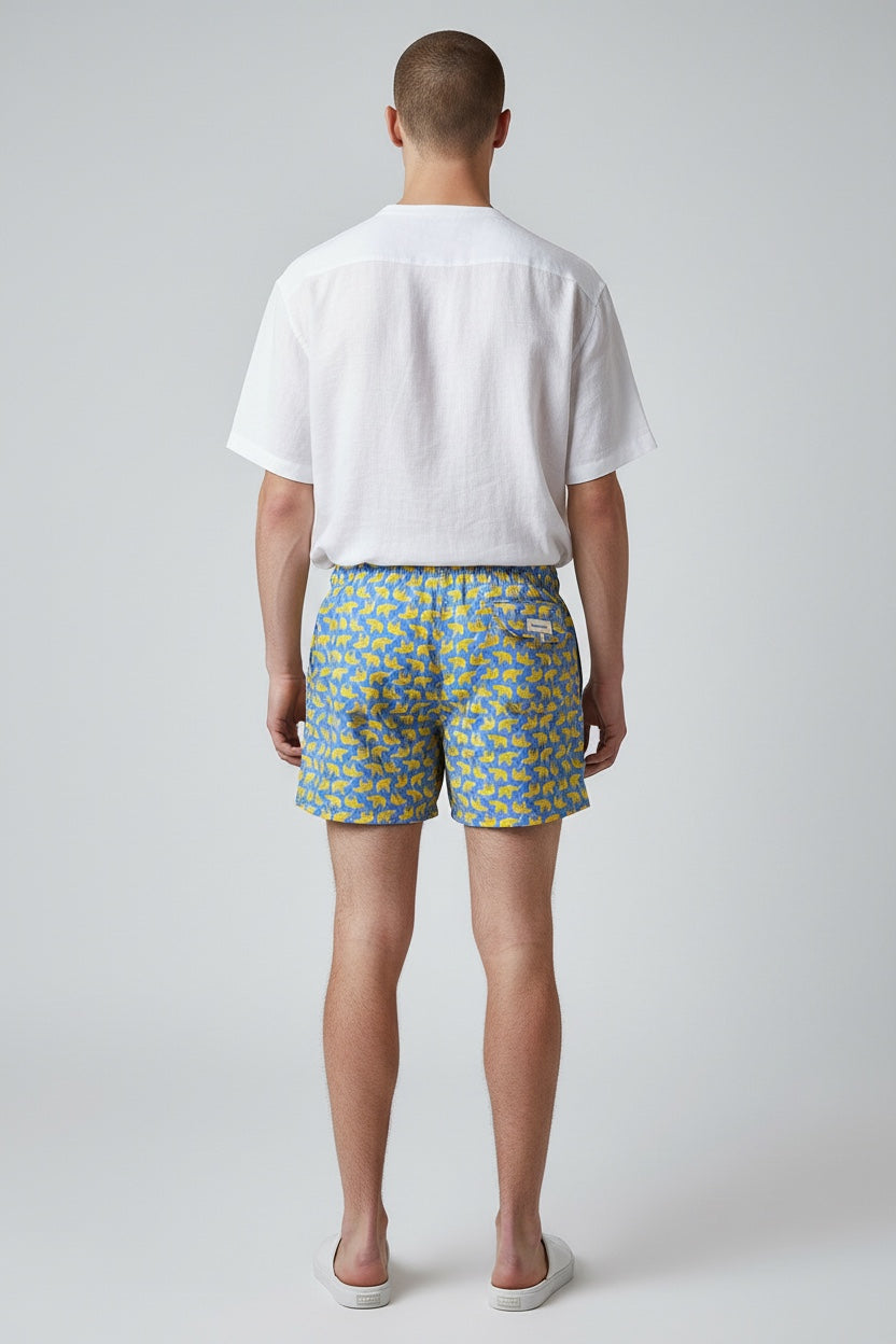 98 Coast men's blue elephant print swim shorts styled with a white shirt for a casual resort look.
