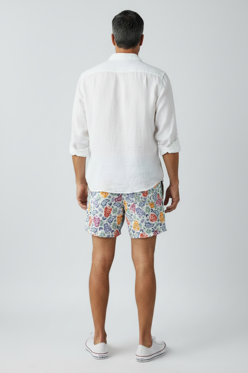 98 Coast Av. Men's swim shorts featuring vibrant multicolor sugar skull print on a light background with a drawstring, model, back view