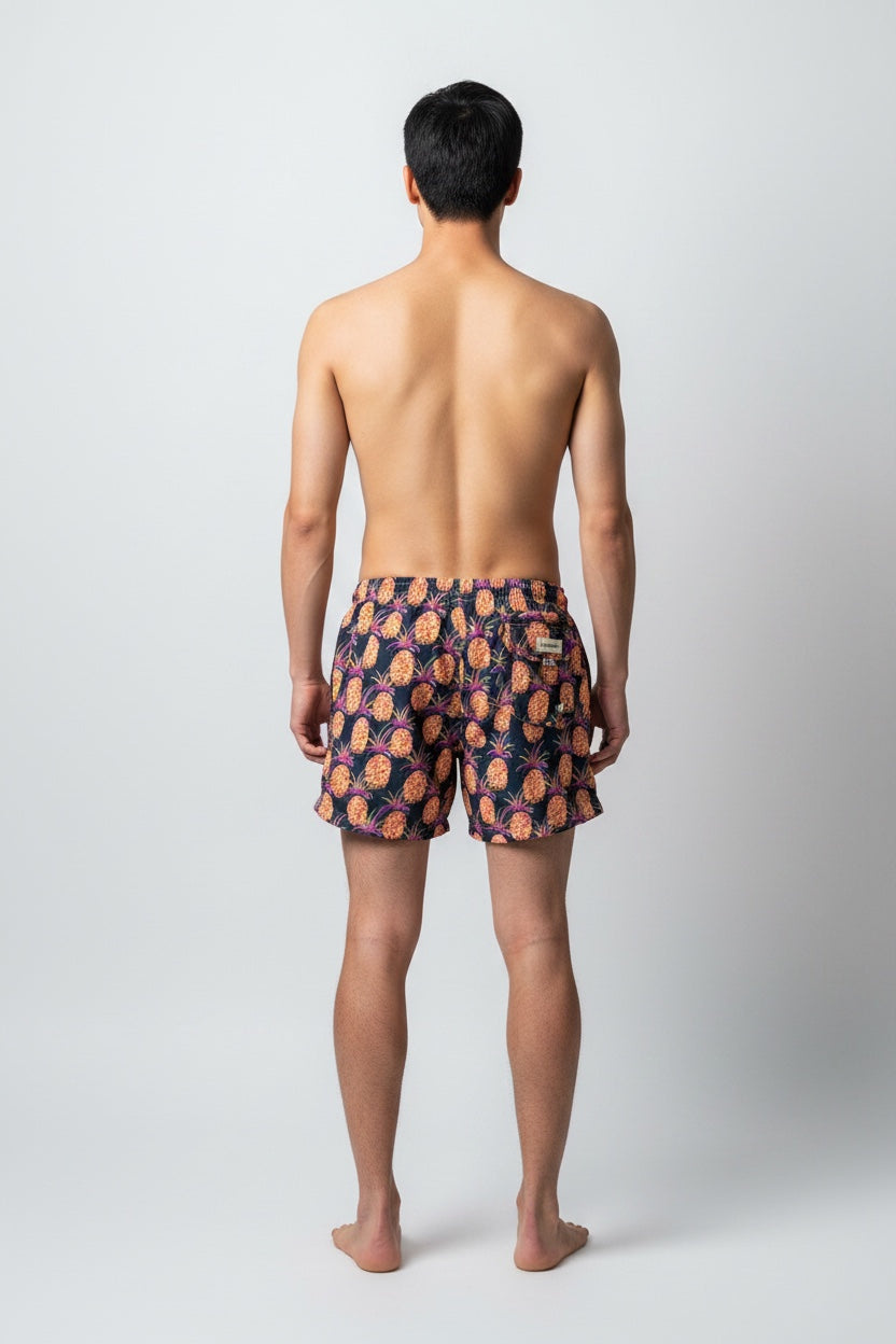 98 Coast Av. men's navy blue swim shorts with tropical pineapple print, elastic waistband and white drawstring, model, back view